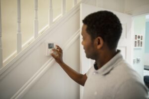 Man Pressing Smart Thermostat